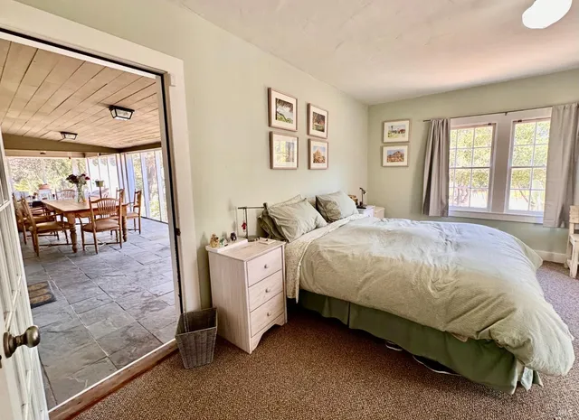 a spacious bedroom with a bed and glass window