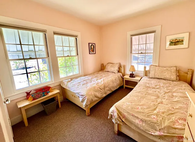 a bedroom with two beds and a window