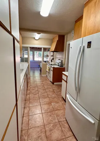 a kitchen with stainless steel appliances granite countertop a refrigerator a stove and a sink