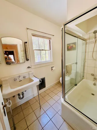 a bathroom with a sink mirror and a bathtub