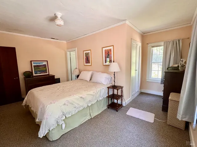 a spacious bedroom with a bed and wooden floor