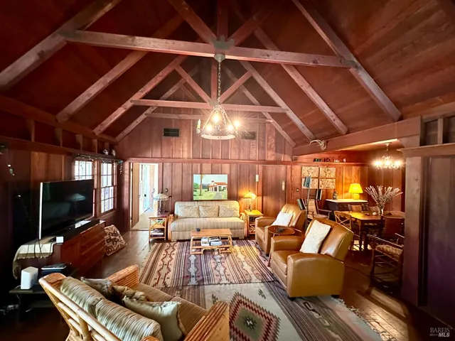 a view of a dining room with furniture a chandelier and wooden floor