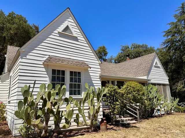 a view of a white house with many windows and potted plants