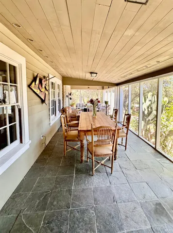 a dining room with furniture and a floor to ceiling window