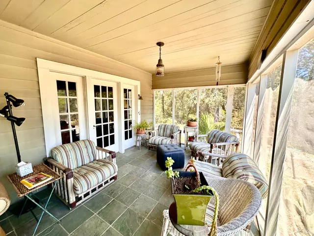 a living room with furniture and floor to ceiling windows