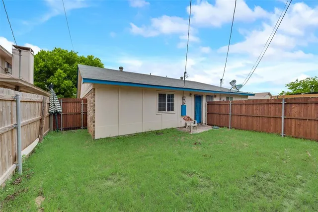 a view of backyard with small cabin and wooden fence