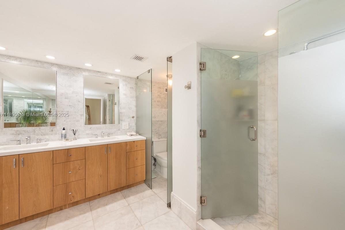 1121 Crandon Boulevard, Unit D402 Key Biscayne, FL 33149 - Photo 11 of 26 a bathroom with a double vanity sink mirror and double