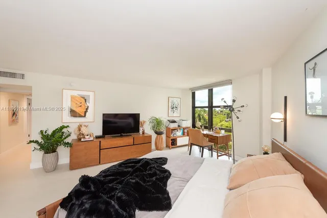 a bedroom with furniture and a flat screen tv