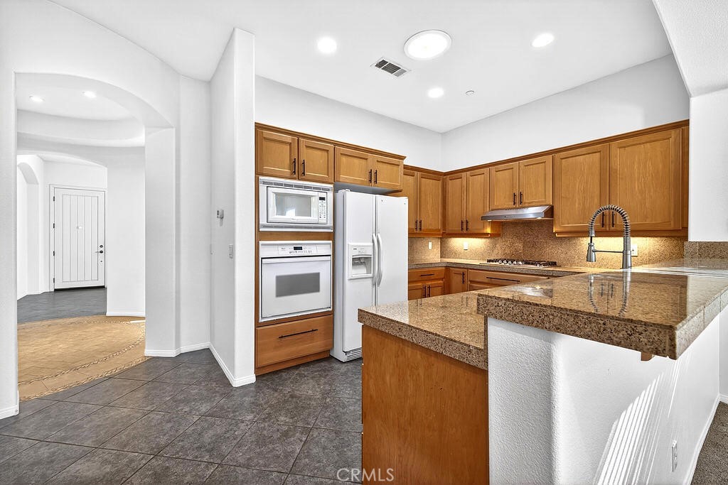 41 Vista Mirage Way Rancho Mirage, CA 92270 - Photo 8 of 25 a kitchen with stainless steel appliances granite countertop a refrigerator and a sink