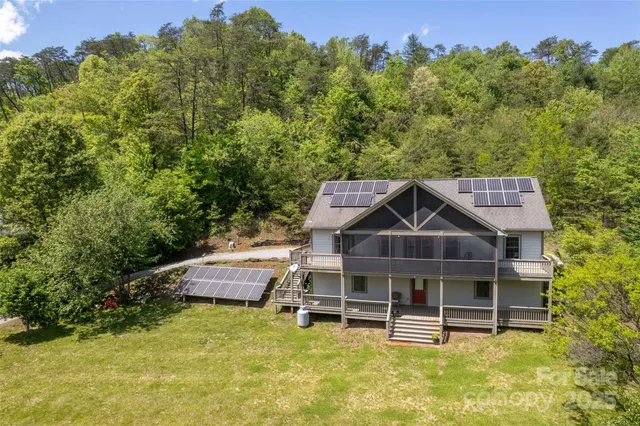 aerial view of a house with a yard balcony and outdoor seating