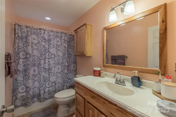 a bathroom with a granite countertop toilet a sink and a mirror