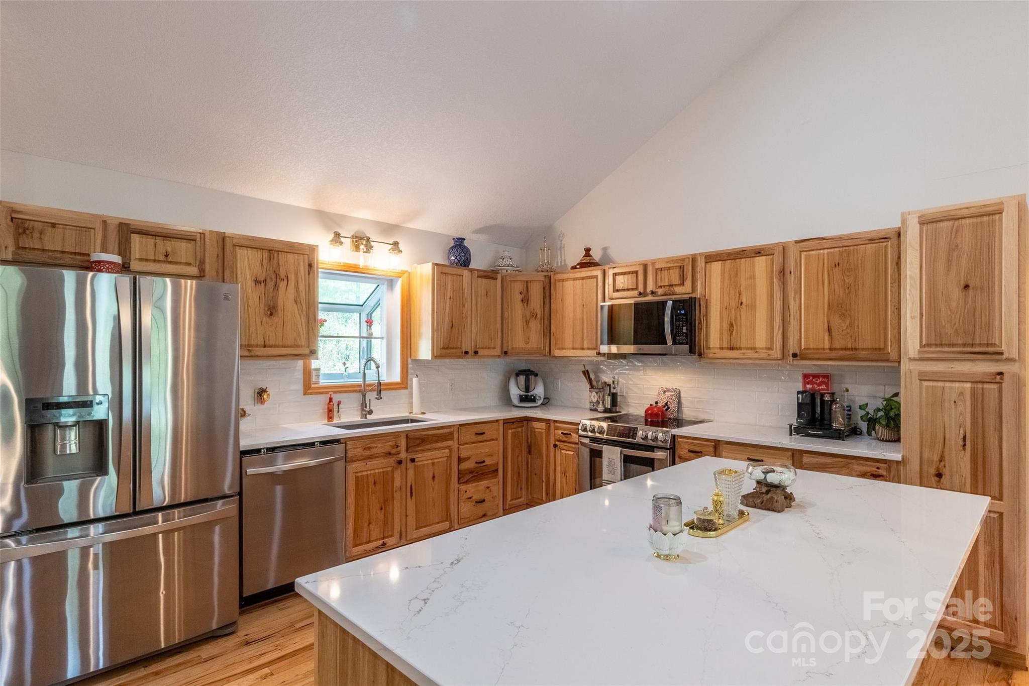 980 South River Road Sylva, NC 28779 - Photo 4 of 41 a kitchen with stainless steel appliances granite countertop a sink a stove and a refrigerator with wooden floor