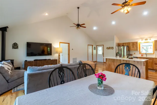 a living room with furniture a flat screen tv and kitchen view