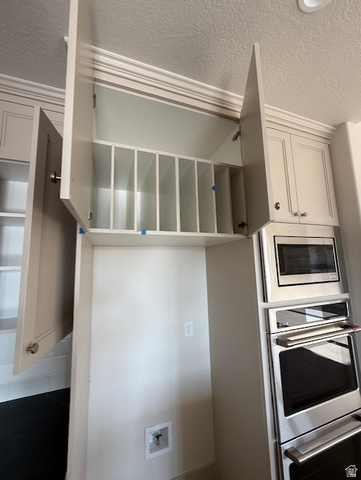533 West S Temple Street, Unit 309 Tooele, UT 84074 - Photo 4 of 24 Kitchen featuring a textured ceiling, appliances with stainless steel finishes, and white cabinetry