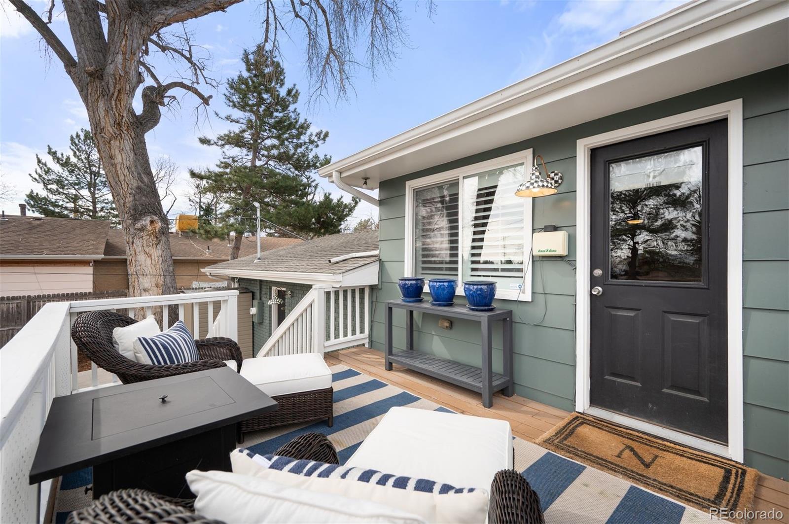 4 Skyline Drive Wheat Ridge, CO 80215 - Photo 14 of 41 a view of a patio with couches table and chairs with wooden floor and fence