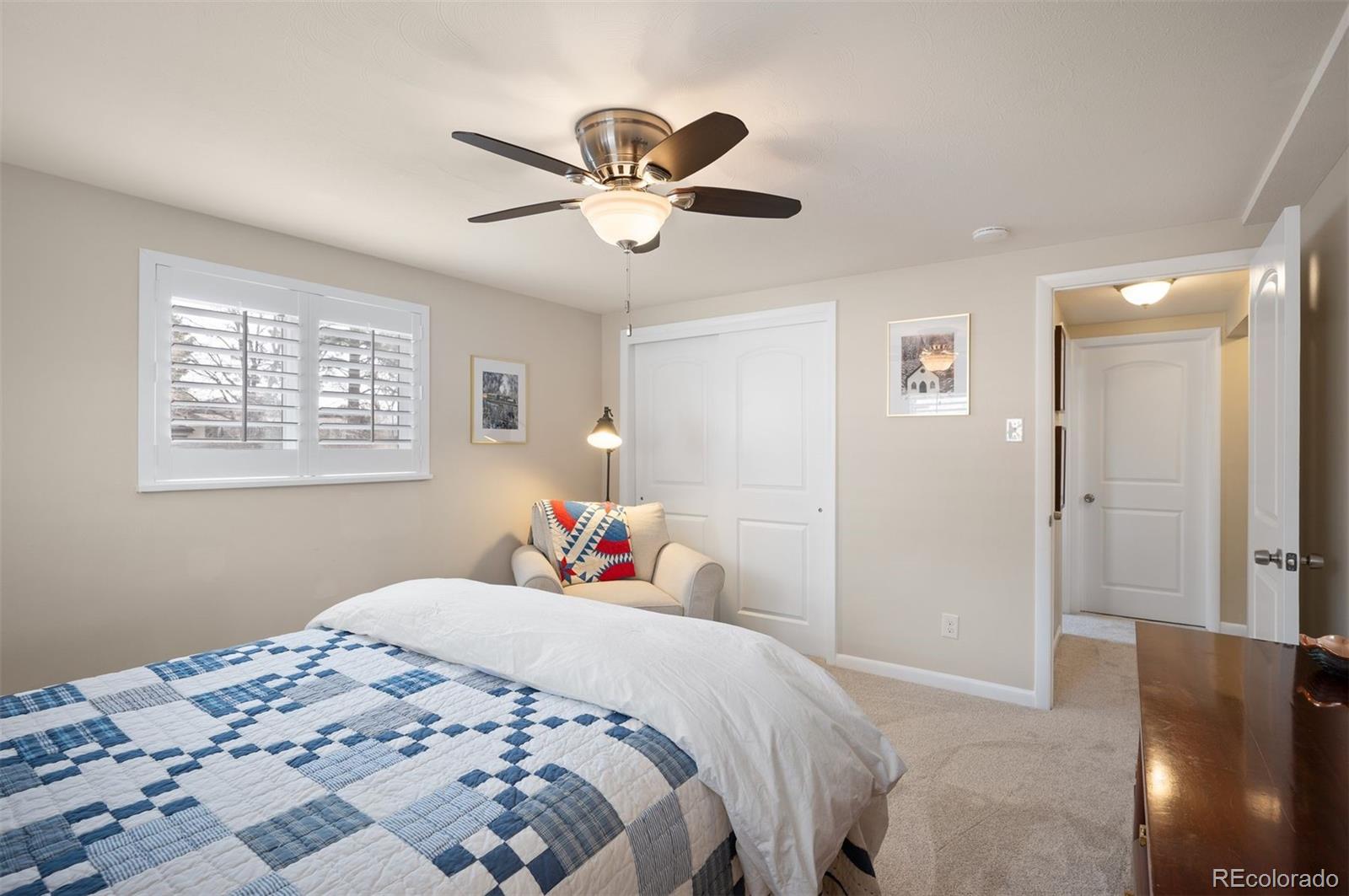 4 Skyline Drive Wheat Ridge, CO 80215 - Photo 28 of 41 a bedroom with a bed and a chandelier