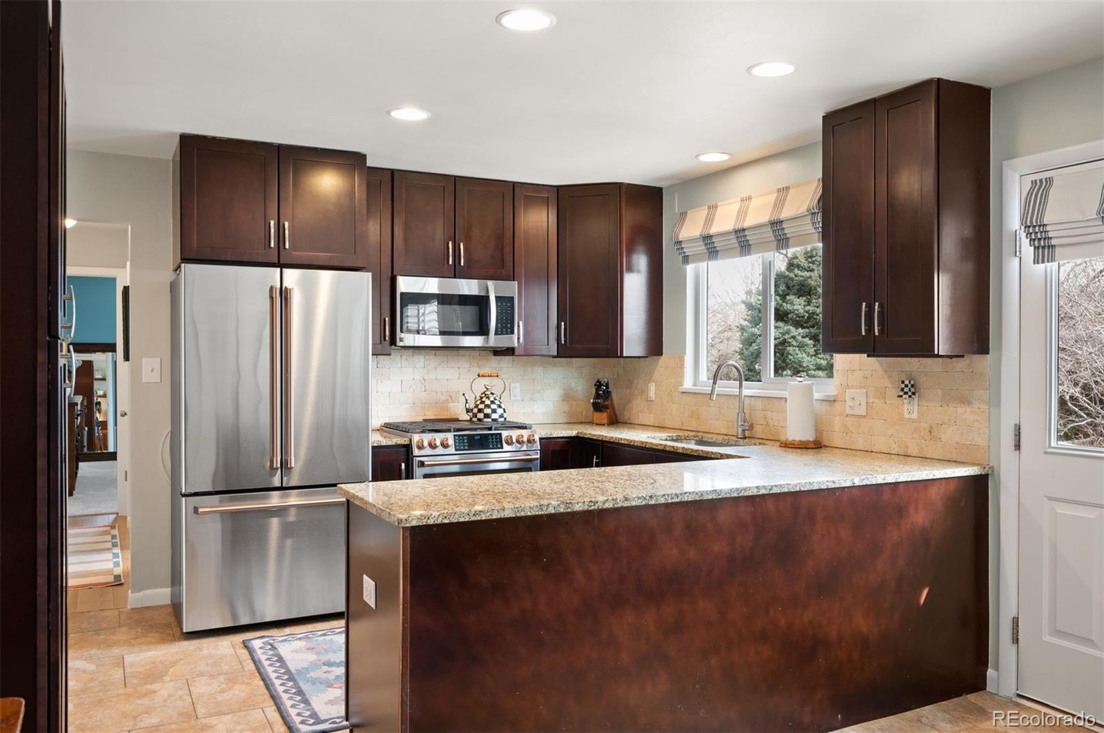 4 Skyline Drive Wheat Ridge, CO 80215 - Photo 10 of 41 a kitchen with granite countertop stainless steel appliances a refrigerator sink and microwave