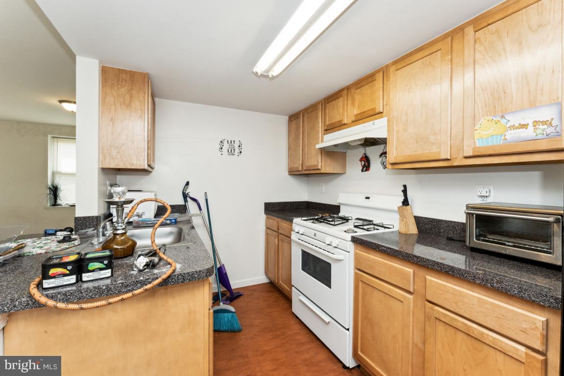 1712 W Street Southeast, Unit 18 Washington, DC 20020 - Photo 7 of 20 a kitchen with stainless steel appliances granite countertop a sink stove and cabinets