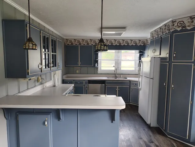 a kitchen with a sink refrigerator and cabinets
