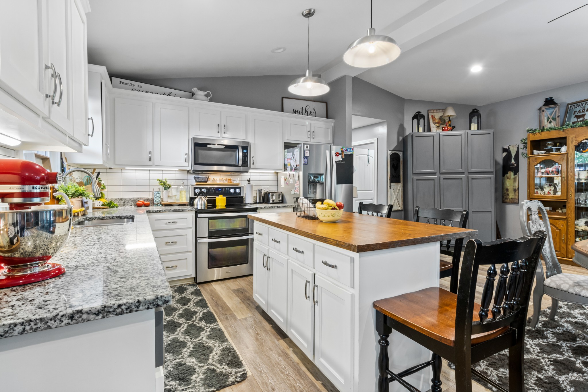 408 Sandy Road Dover, TN 37058 - Photo 8 of 36 a kitchen with stainless steel appliances granite countertop a stove top oven a refrigerator a sink and a dining table with white cabinets