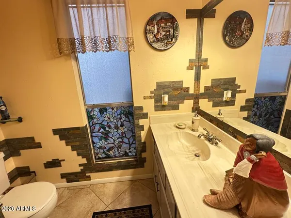 a bathroom with a sink mirror vanity and toilet