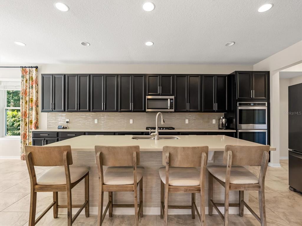 17422 Channel Way Winter Garden, FL 34787 - Photo 11 of 44 a kitchen with stainless steel appliances a stove a table and chairs