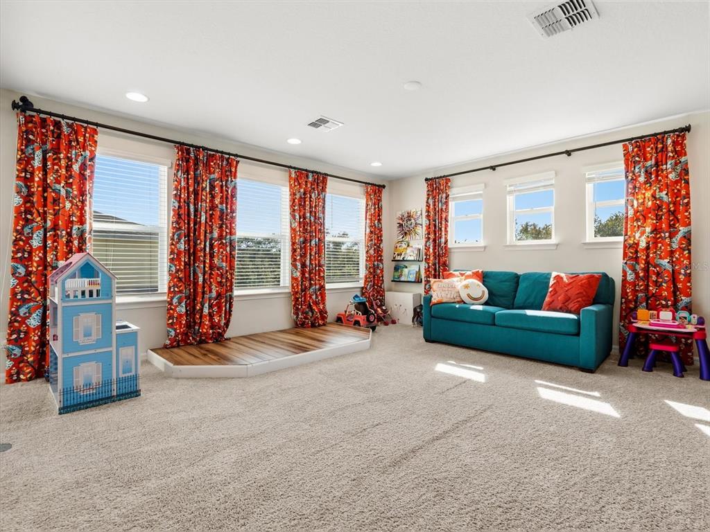 17422 Channel Way Winter Garden, FL 34787 - Photo 24 of 44 a living room with furniture and a floor to ceiling window