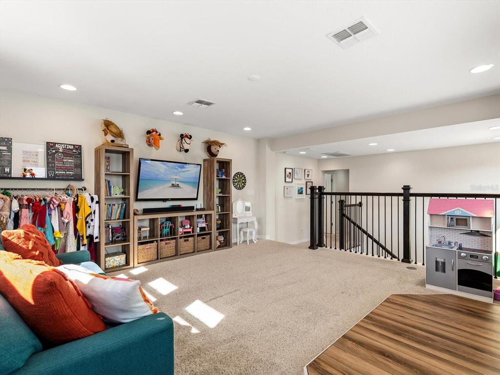 17422 Channel Way Winter Garden, FL 34787 - Photo 25 of 44 a living room with furniture a flat screen tv and a wall painting