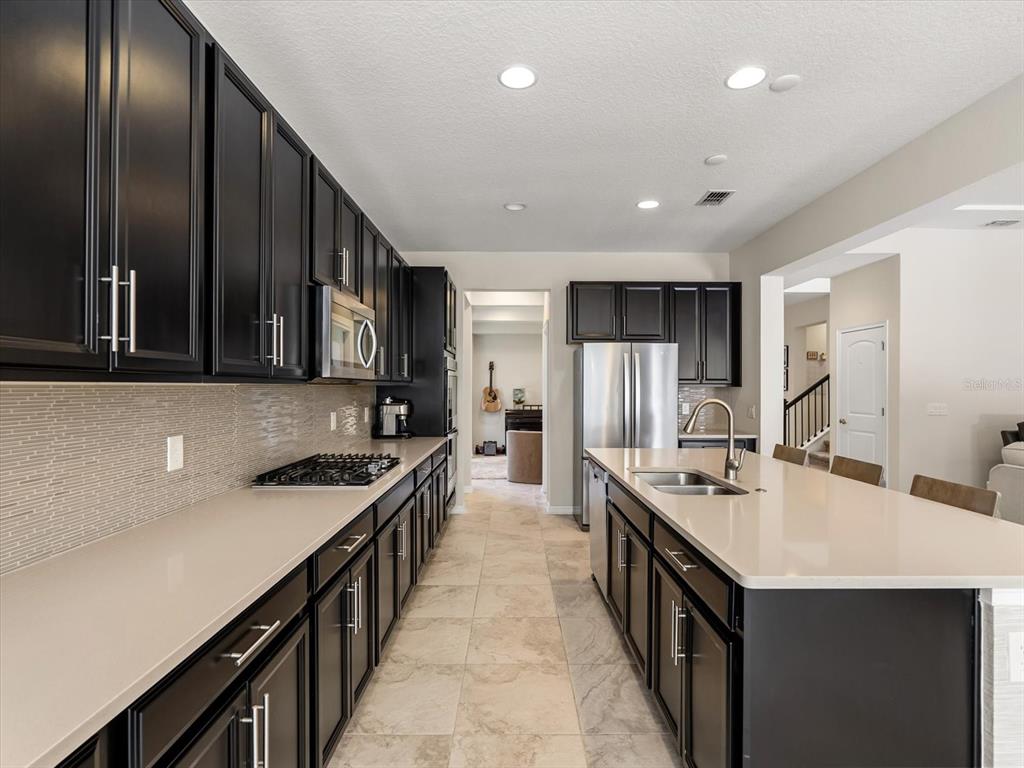 17422 Channel Way Winter Garden, FL 34787 - Photo 9 of 44 a kitchen with stainless steel appliances a sink stove top oven and cabinets