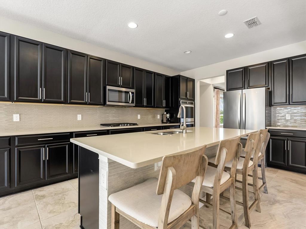 17422 Channel Way Winter Garden, FL 34787 - Photo 10 of 44 a kitchen with stainless steel appliances granite countertop a stove a sink a microwave a refrigerator and cabinets