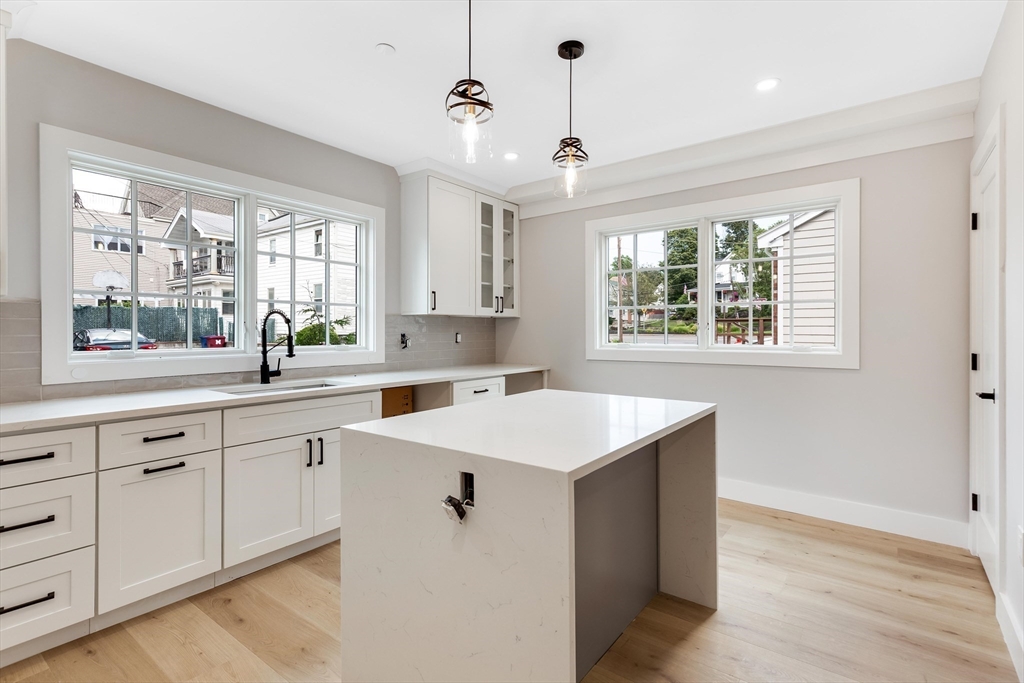 a kitchen with a sink window and cabinets