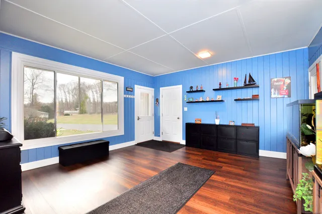 a spacious bedroom with a bed a dresser next to a window