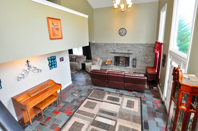 a living room with furniture a fireplace and a large window