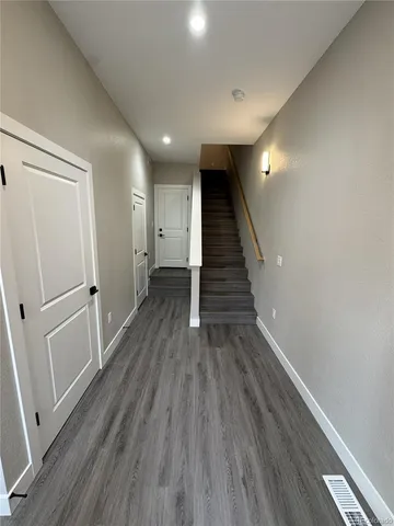 a view of a hallway with wooden floor and staircase