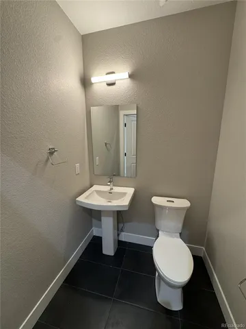 a bathroom with a sink toilet and a mirror