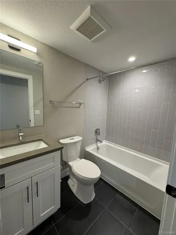 a bathroom with a bathtub shower sink mirror and toilet