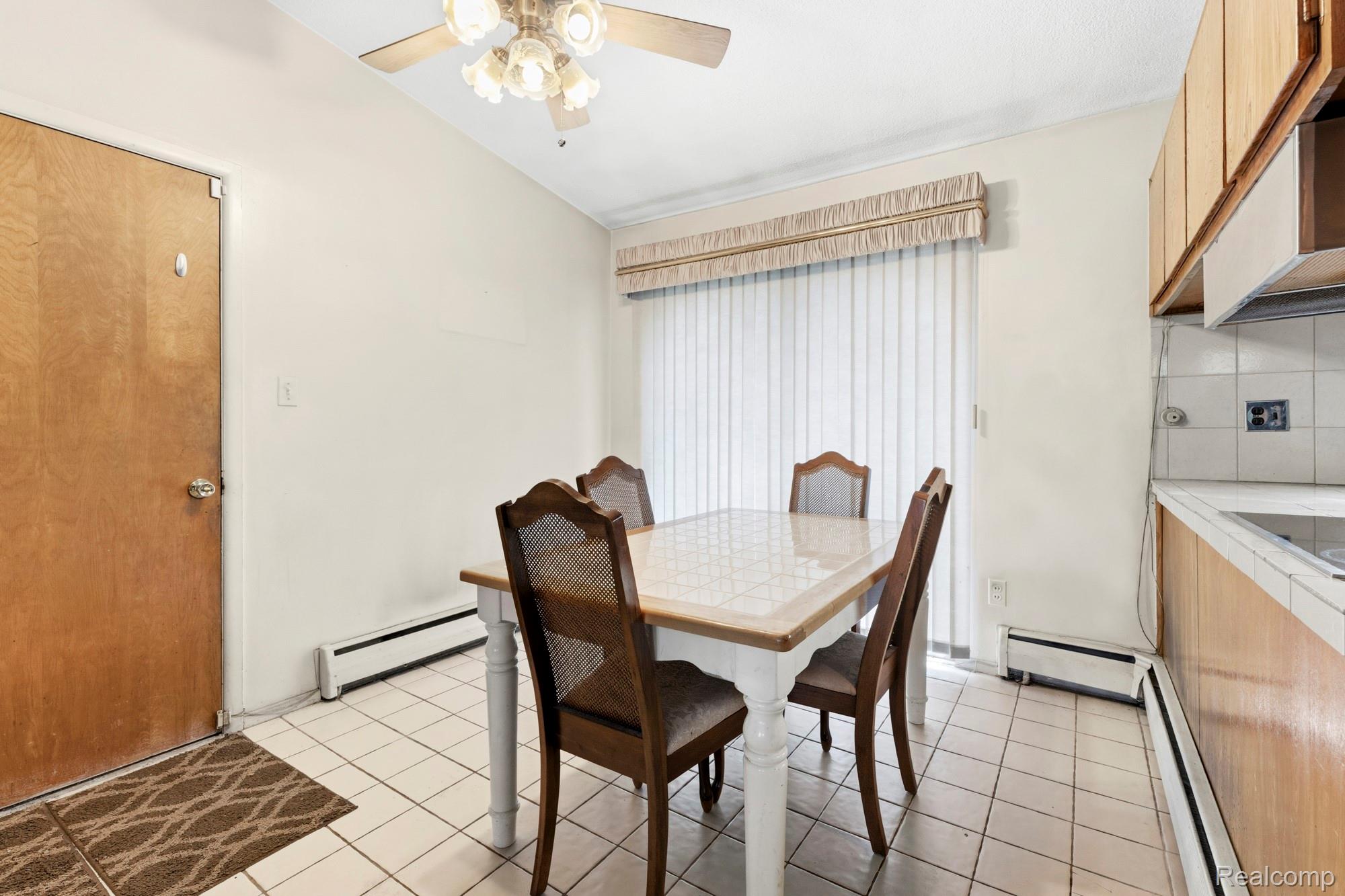 23410 Joy Road Redford, MI 48239 - Photo 6 of 25 Dining area with a ceiling fan, a baseboard heating unit, light tile patterned flooring, baseboard heating, and lofted ceiling