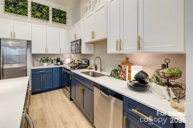 a kitchen with stainless steel appliances a sink a stove and a refrigerator