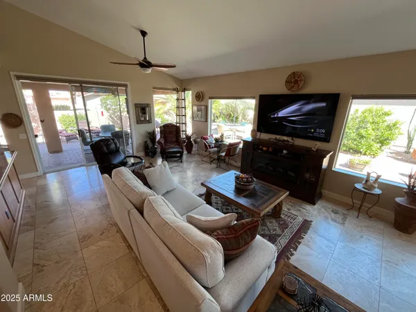 a living room with furniture flat screen tv and a large window