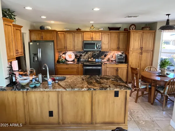 a kitchen with stainless steel appliances granite countertop a stove refrigerator and cabinets