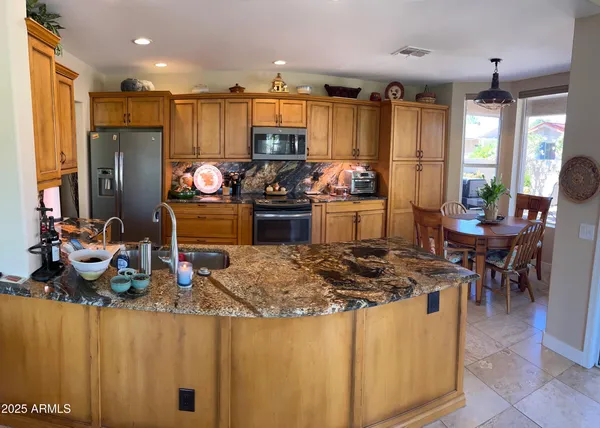 a kitchen with refrigerator and chairs