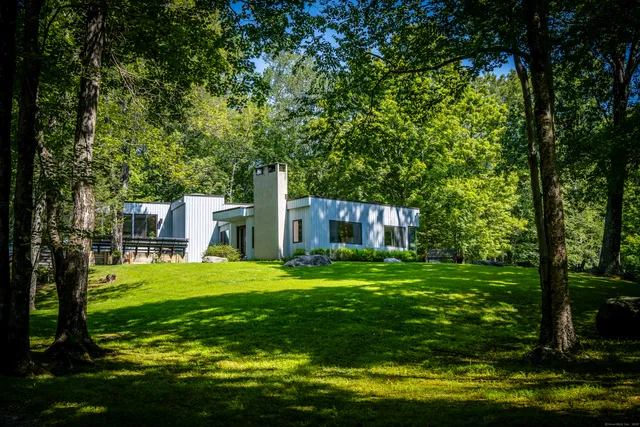 a backyard of a house with a garden and outdoor seating