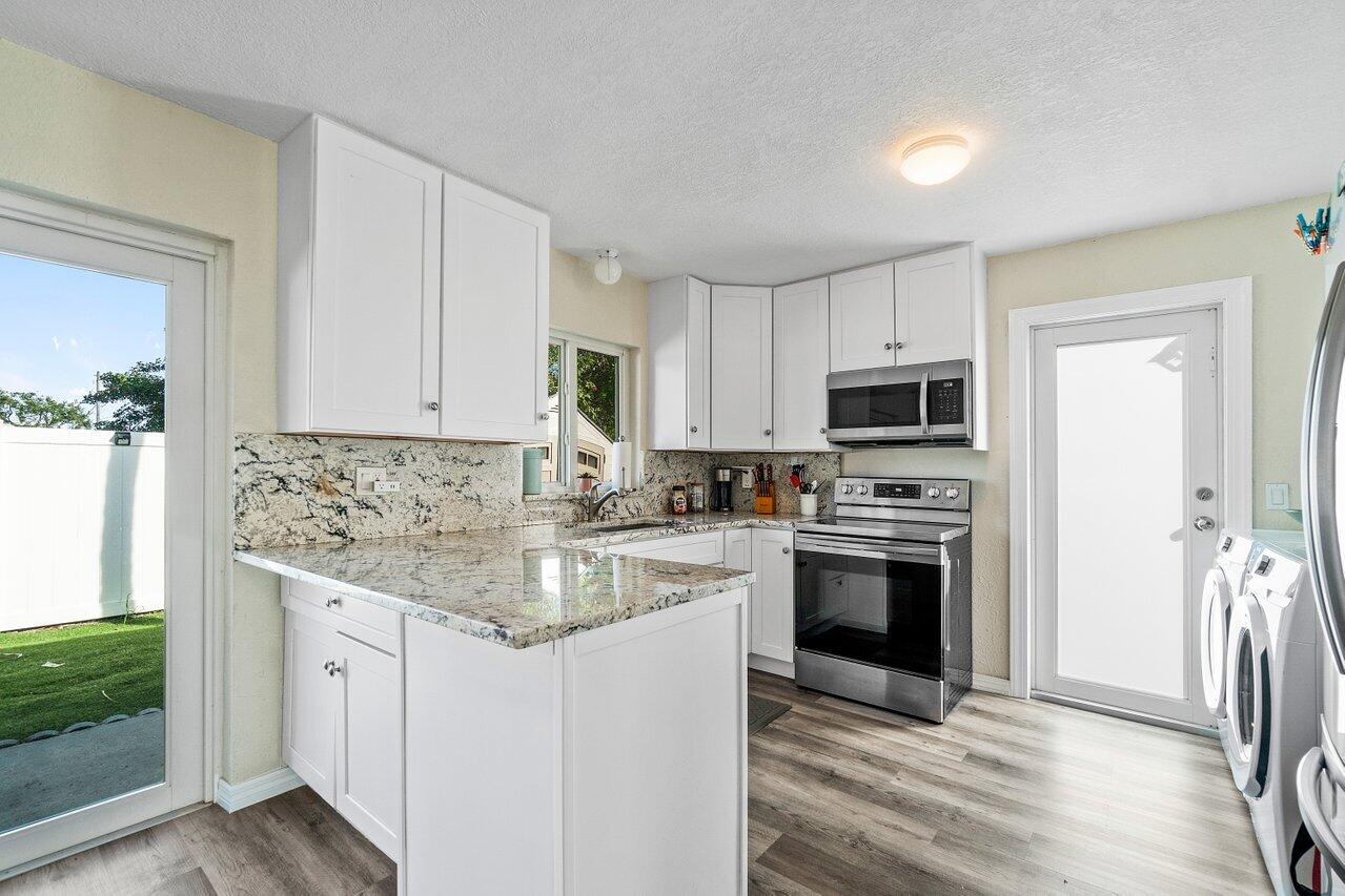 119 Southeast 5th Street Delray Beach, FL 33483 - Photo 15 of 27 a kitchen with stainless steel appliances granite countertop a stove a sink and a refrigerator