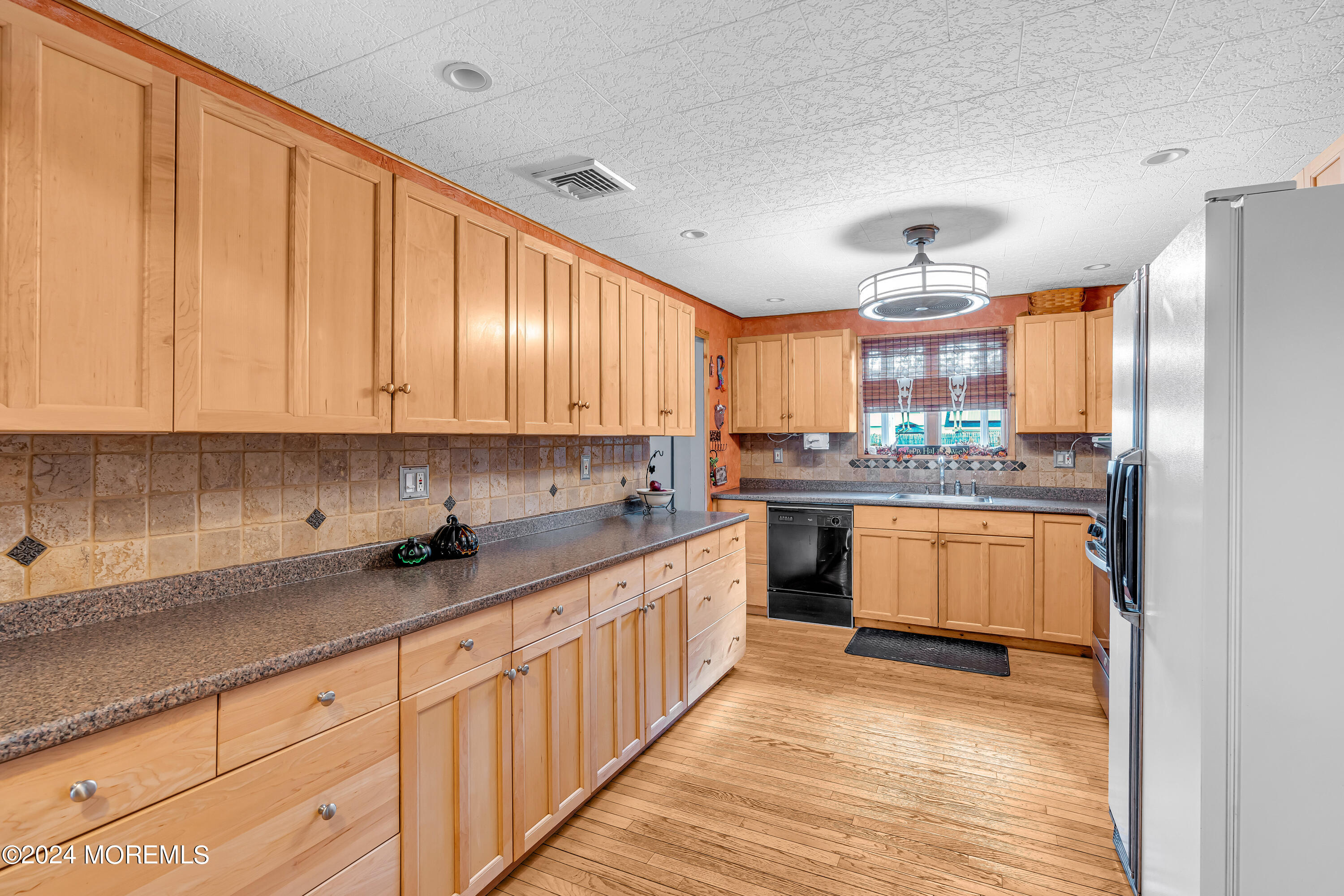 13 Hemlock Road Howell, NJ 07731 - Photo 15 of 48 a kitchen with kitchen island granite countertop wooden cabinets stainless steel appliances a sink and a window