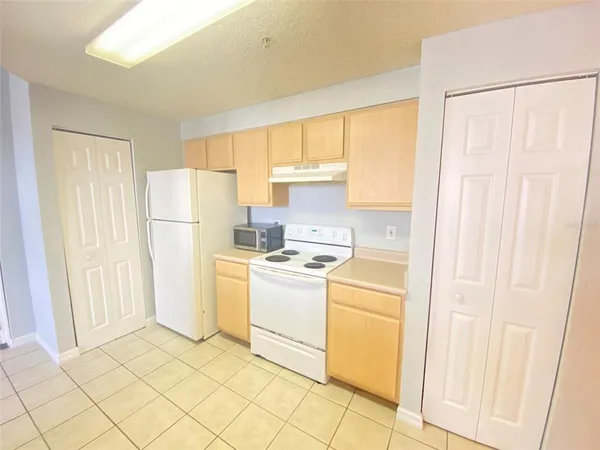 a kitchen with a refrigerator sink stove and cabinets