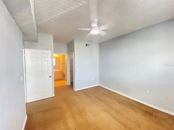 an empty room with closet and a ceiling fan