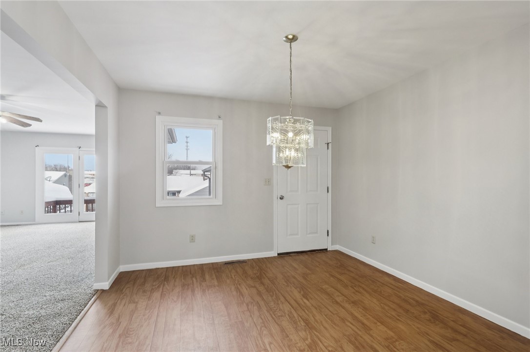 611 Wilson Street Struthers, OH 44471 - Photo 8 of 44 Unfurnished dining area featuring wood finished floors and a chandelier