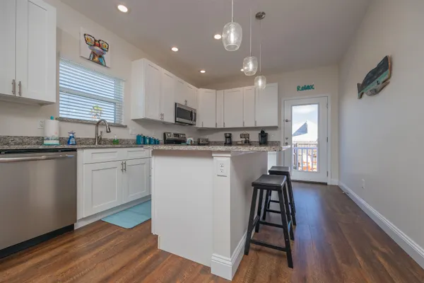 a kitchen with stainless steel appliances granite countertop a stove a microwave and a sink