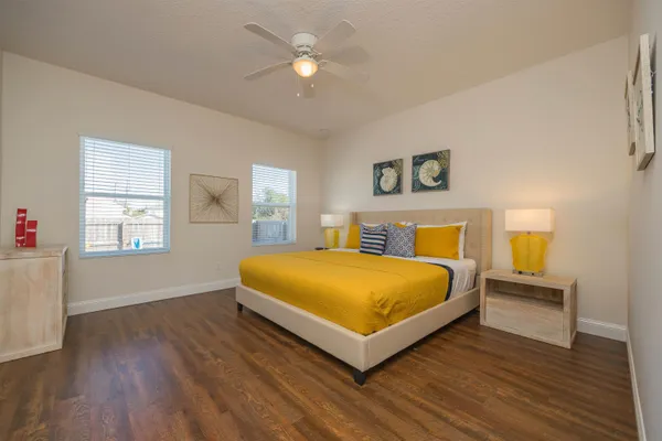 a spacious bedroom with a bed and wooden floor