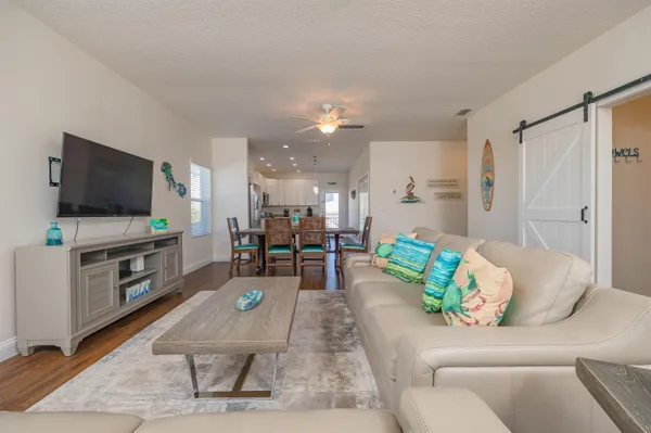 a living room with furniture a flat screen tv and a window